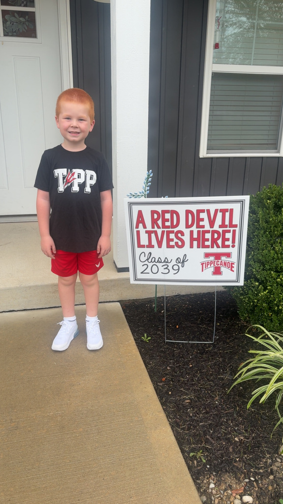 On the first day of school a kindergarten student poses with the Class of 2039 sign.