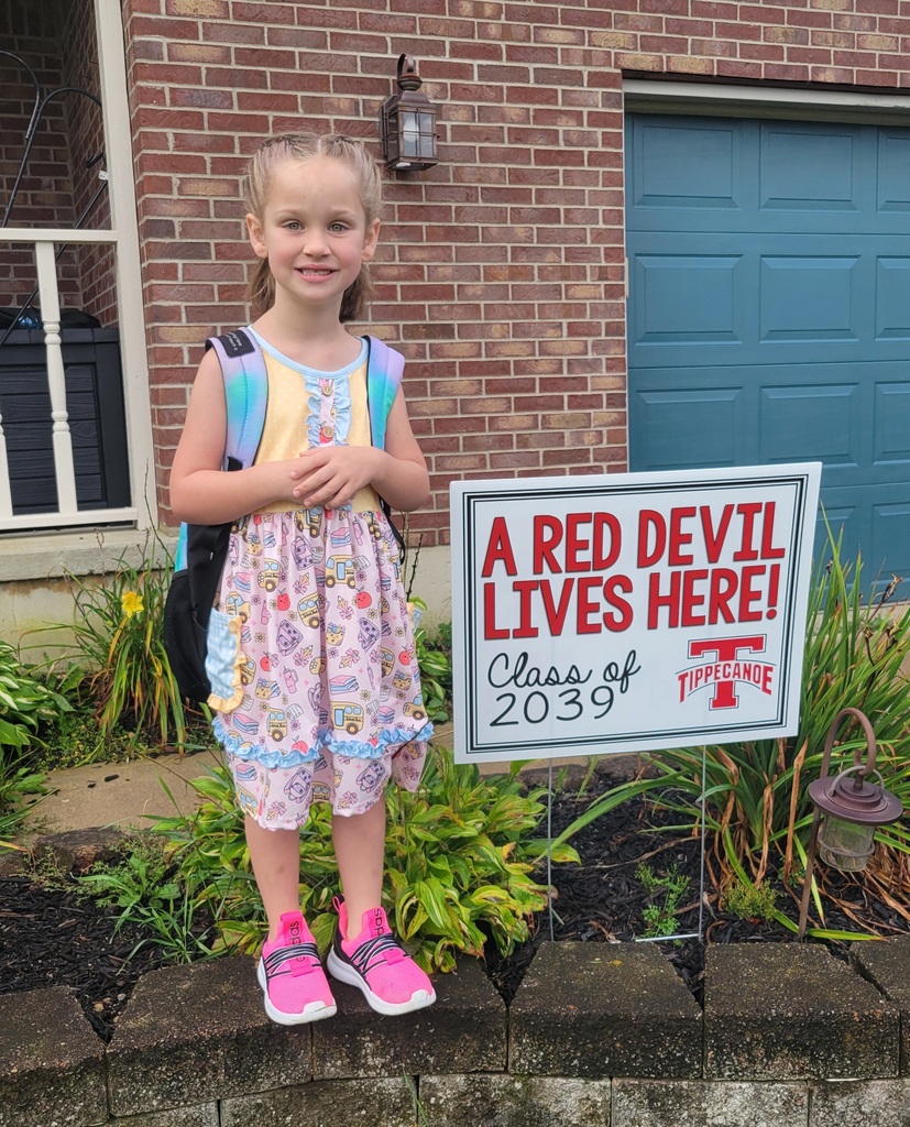 On the first day of school a kindergarten student poses with the Class of 2039 sign.