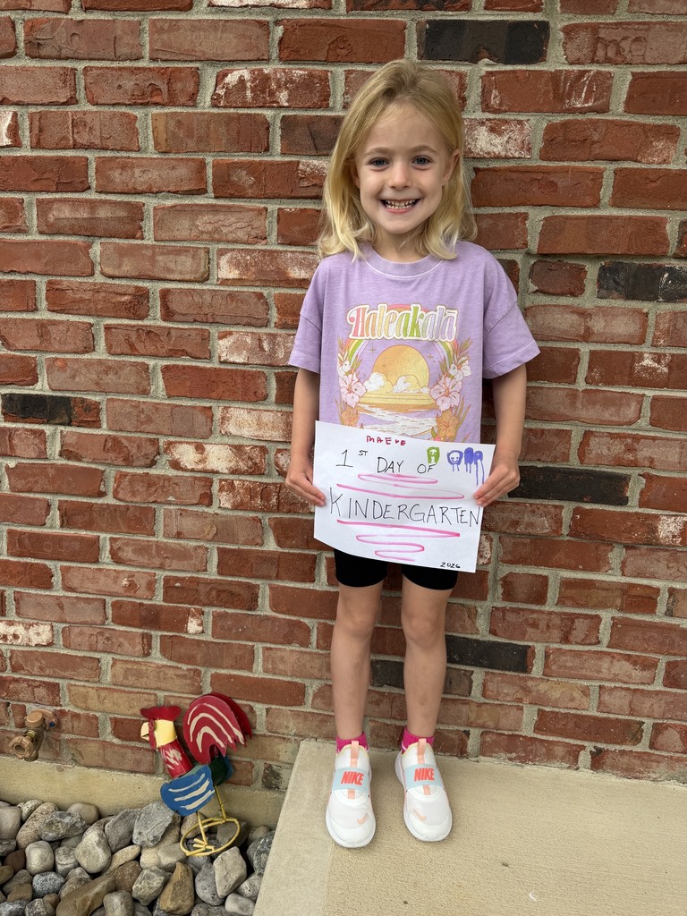 On the first day of school a kindergarten student poses for a before school photo.