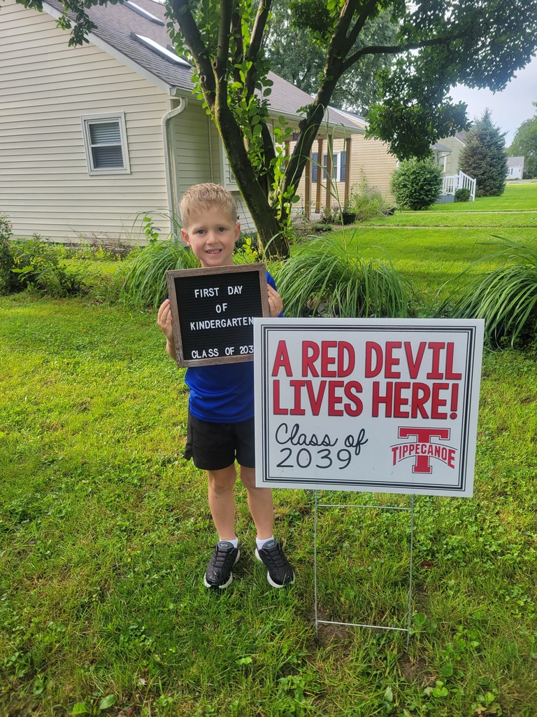 On the first day of school a kindergarten student poses with the Class of 2039 sign.