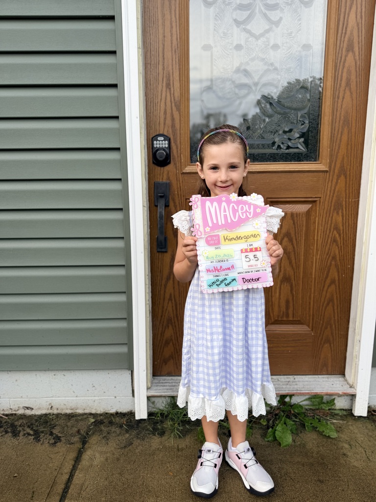 On the first day of school a kindergarten student poses with the Class of 2039 sign.