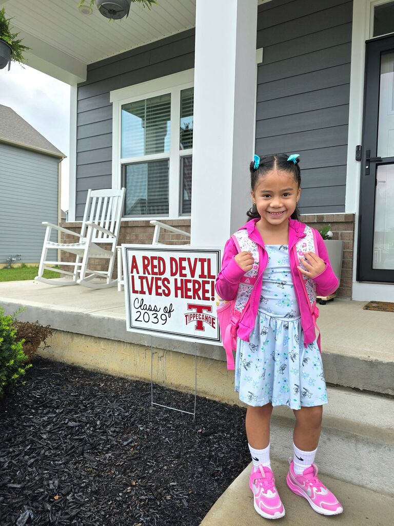 A first day kindergarten picture with one of our students and the Class of 2039 yard sign.