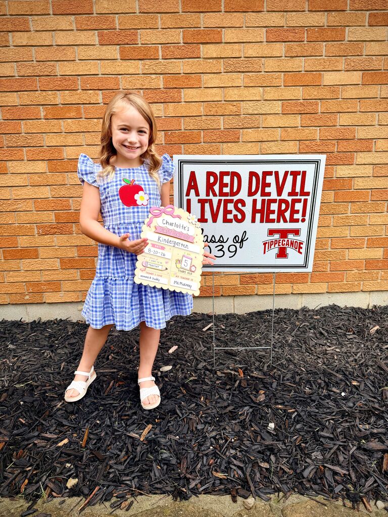 A first day kindergarten picture with one of our students and the Class of 2039 yard sign.