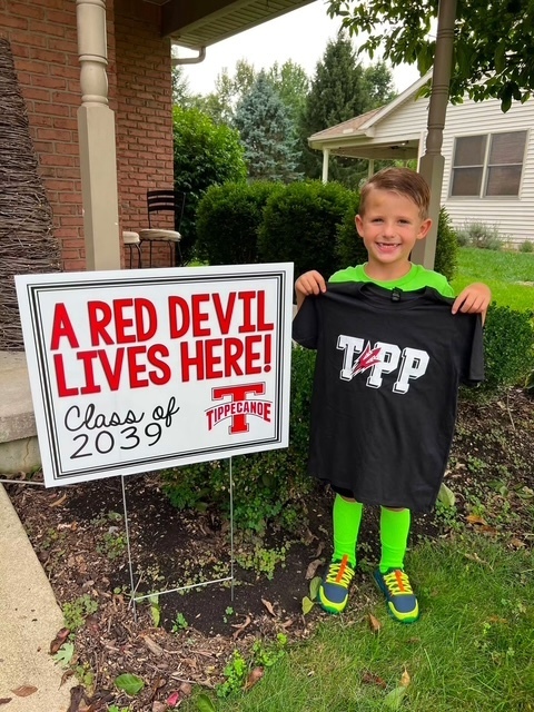 A Broadway Elementary student is all smiles with his Class of 2039 sign and t-shirt delivered by kindergarten teachers.