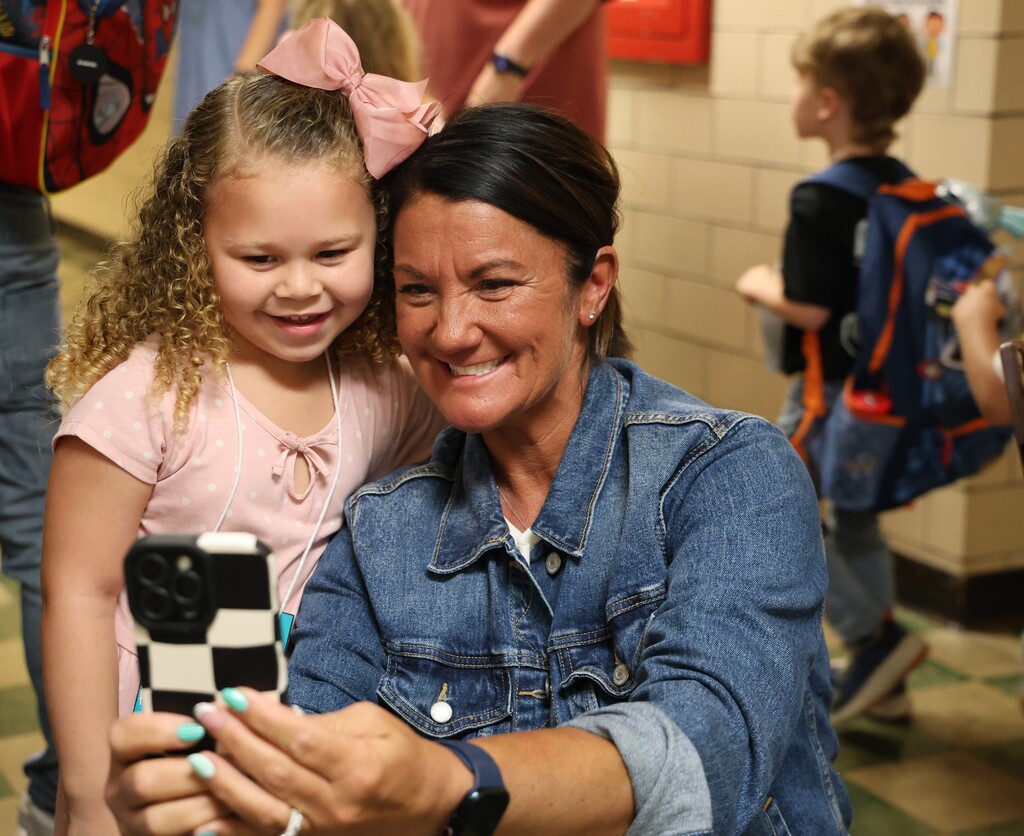 A Broadway Elementary student is all smiles on the first day of kindergarten as she takes a selfie with a teacher.