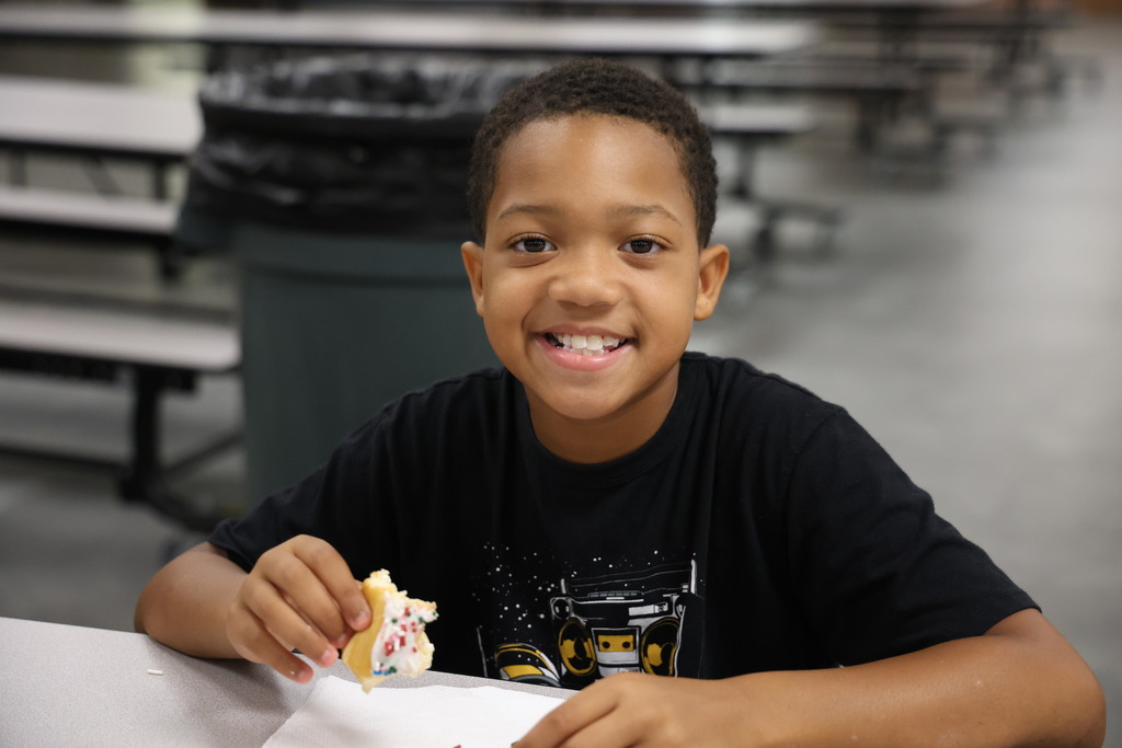 A new student enjoys a donut as he joins other classmates to get better acclimated to the district.