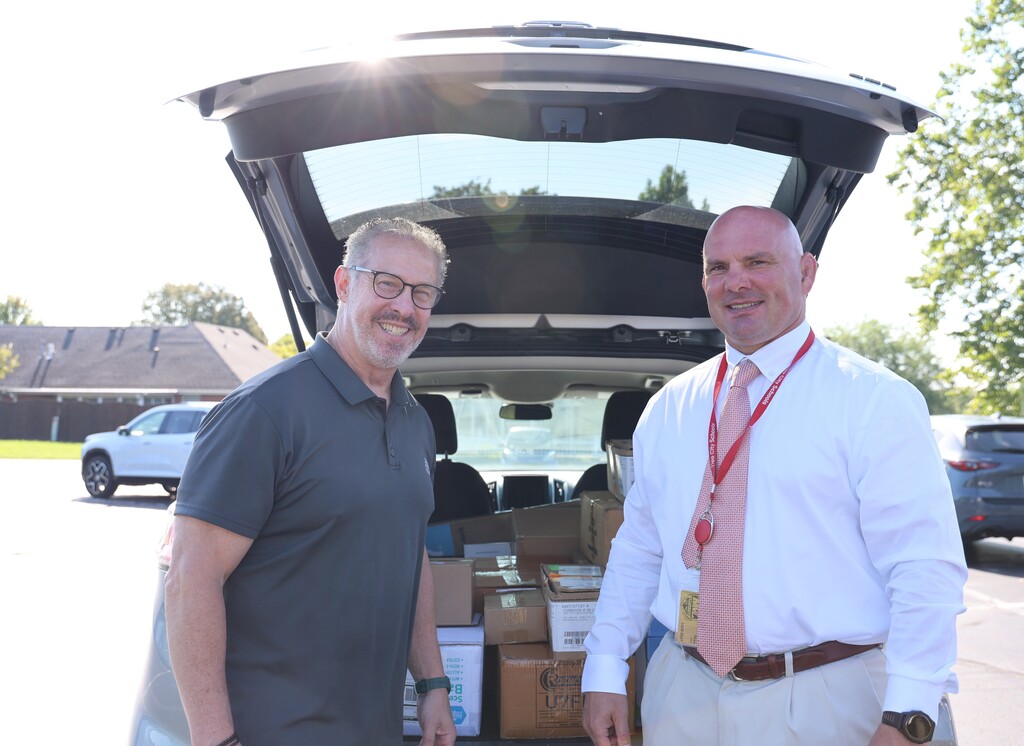 Superintendent is pictured with Dap Plant Manager to accept a donation of school supplies.