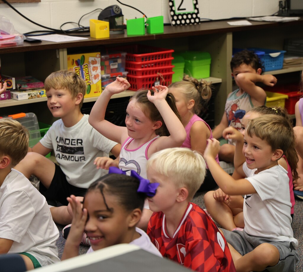 Students make silly faces during story time as they act out the pages of The Book of Rules.