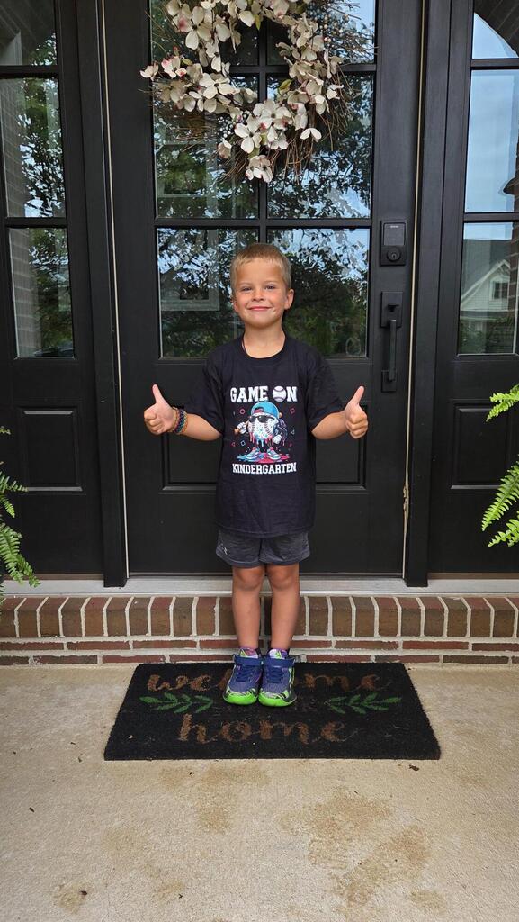 A student is thumbs up for the first day of school.