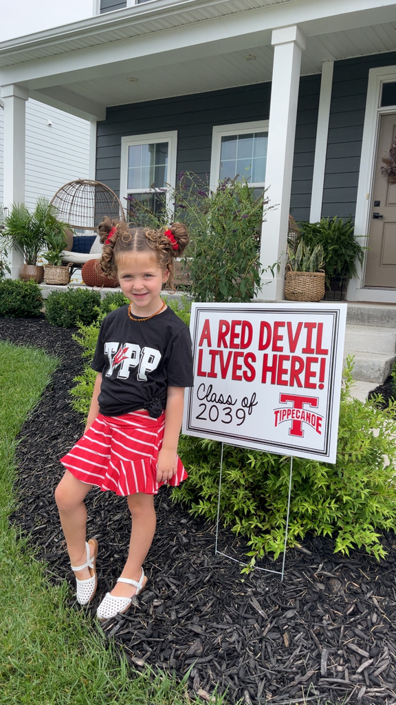 A cute little Red Devil with her yard sign.