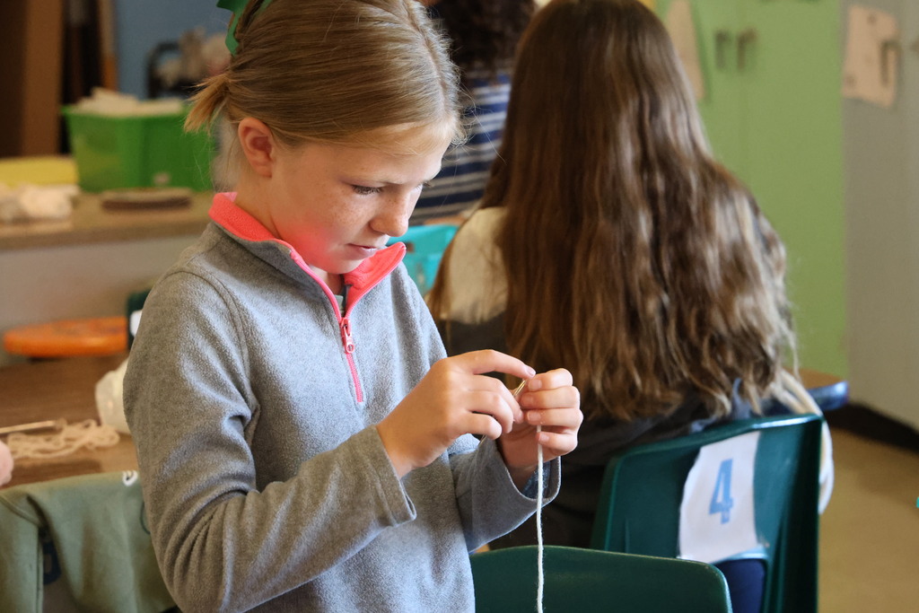 L.T. Ball fifth graders are learning how to weave a basket. A student threads a needle as part of the process.