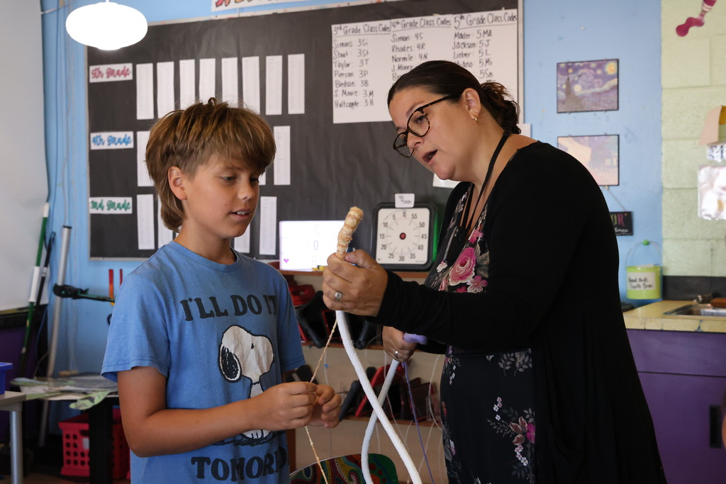 L.T. Ball fifth graders are learning how to weave a basket.  A student gets help from his teacher Shelby Walters.