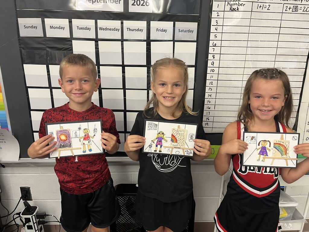 Three Broadway students proudly show off their artwork.  