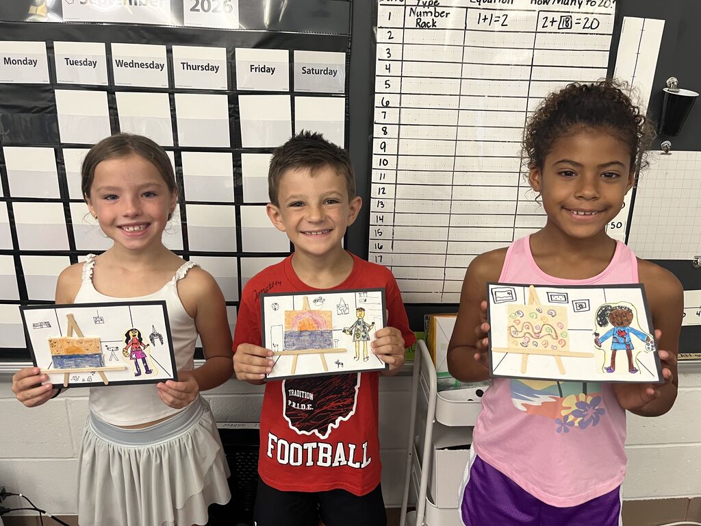 Three Broadway students proudly show off their artwork.  