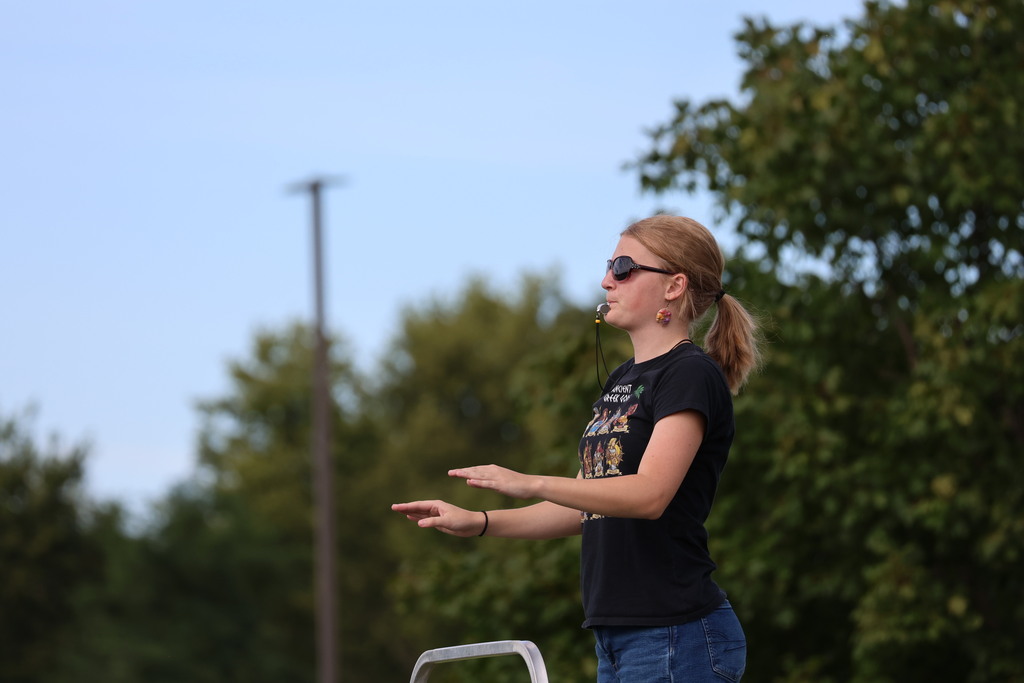 A THS student conductor works with the band.
