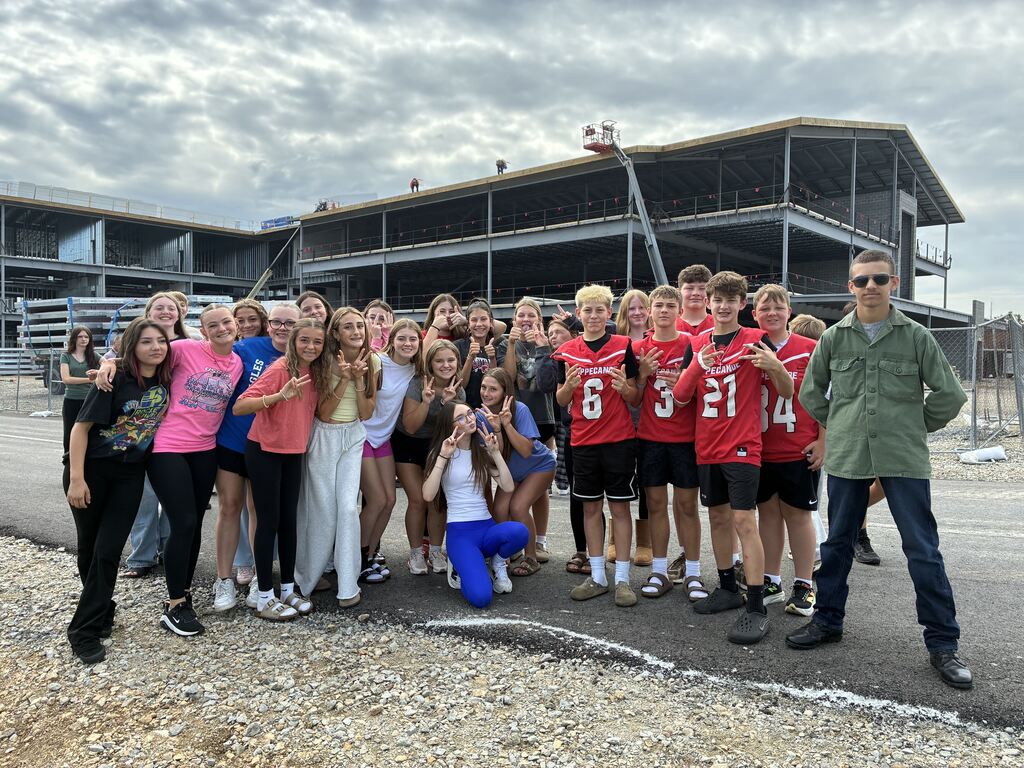 Tippecanoe Middle School students pose for a photo in front of the new school after signing a steel beam for the building.
