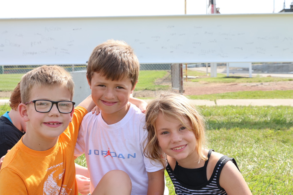 Broadway students pose for the camera while waiting for the school bus after signing the beam. 