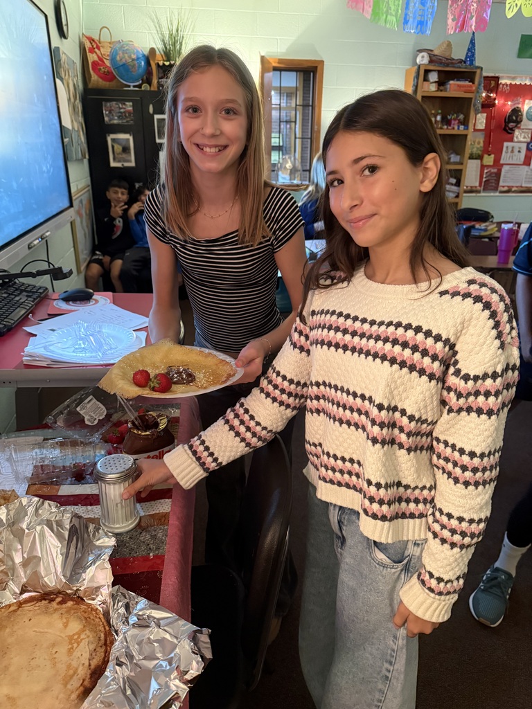 Two TMS girls show off their crepes in their language class.