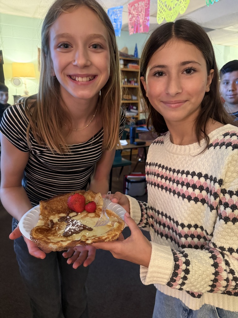 Two TMS girls show off their crepes in their language class.
