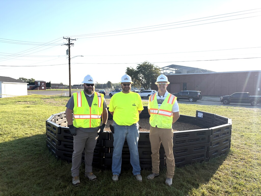 Shook construction employees stand with L.T. Ball's new Gaga Pit they donated.