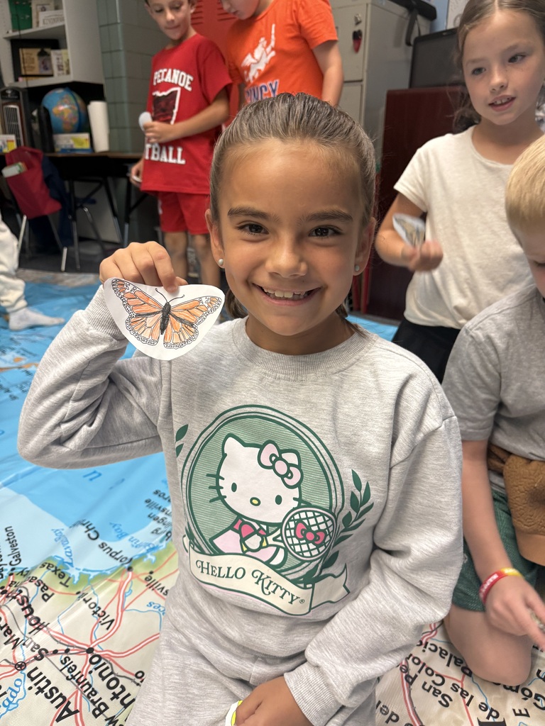 A student shows off her monarch butterfly for the migration.