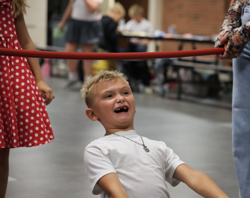 A boy reacts after showing his stuff when doing the limbo.