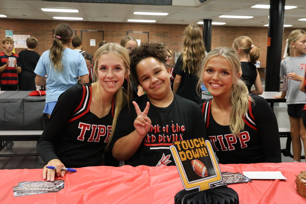 Two cheerleaders with a Red Devils fan.