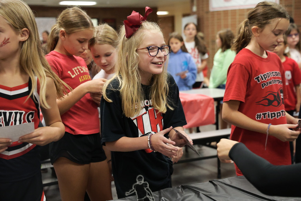 An L.T. Ball student smiles while interacting with a cheerleader.
