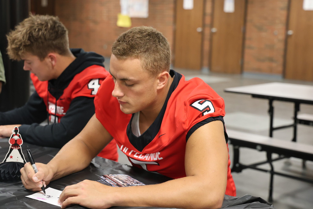 A THS football player signs his autograph.