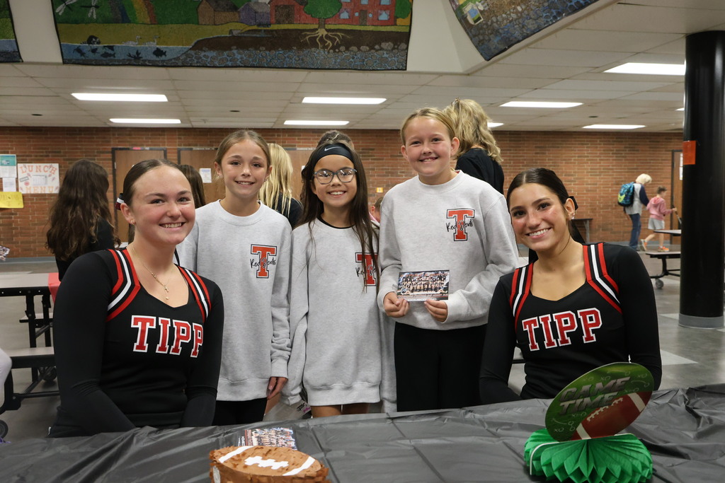 Two cheerleaders pose with three L.T. Ball students who are wearing the same Tipp gear!