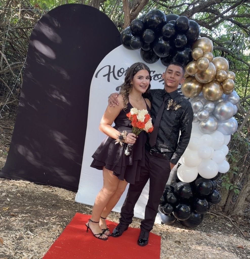 Two students pose for a photo under a balloon arch before the Tippecanoe High School homecoming.