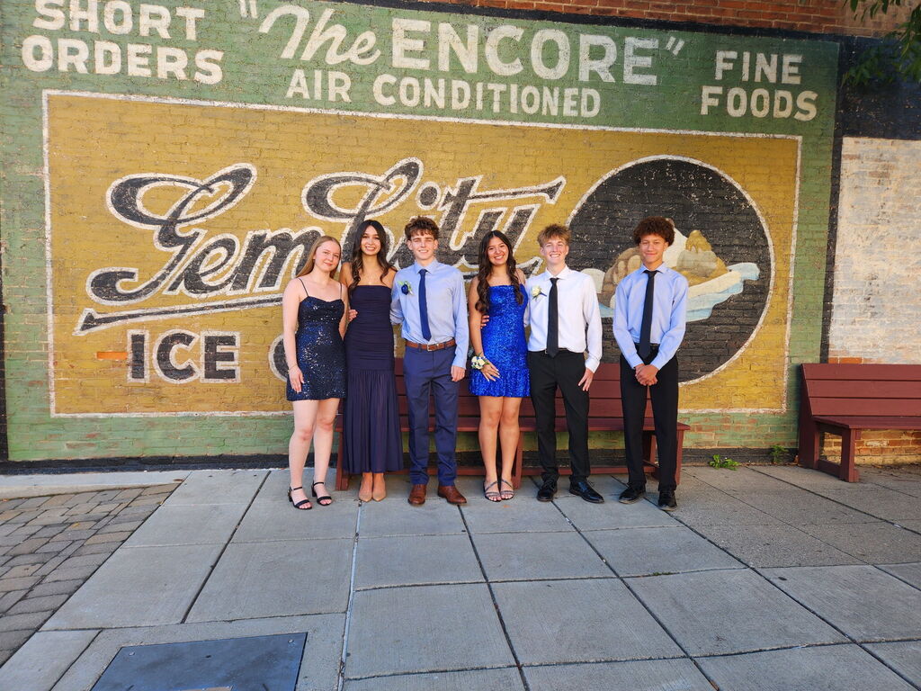 A group of students pose for a photo downtown by the mural before the THS homecoming dance.