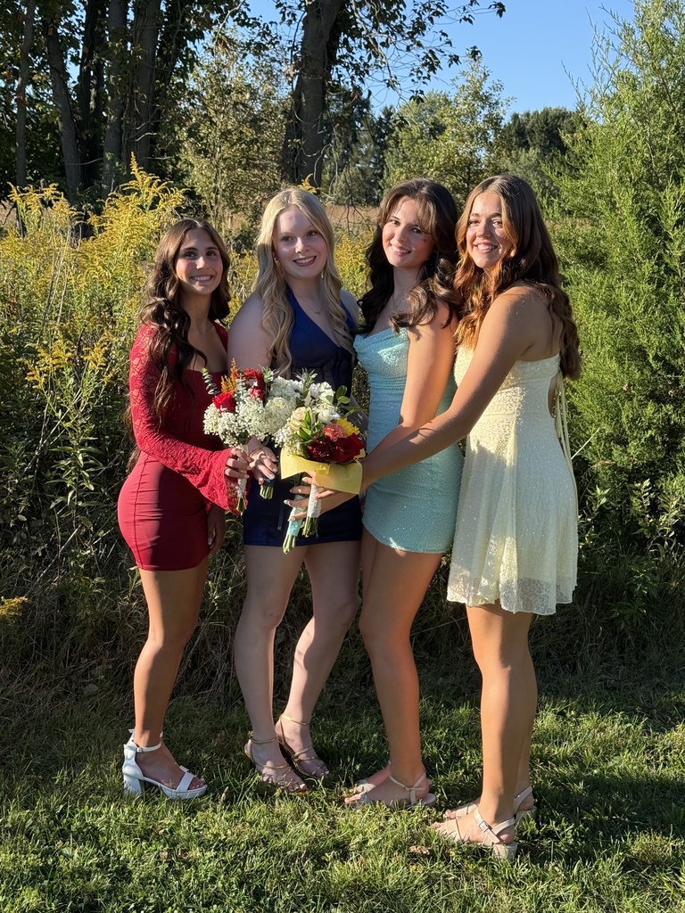 Four students pose for a photo holding their flowers before the Tippecanoe High School homecoming.