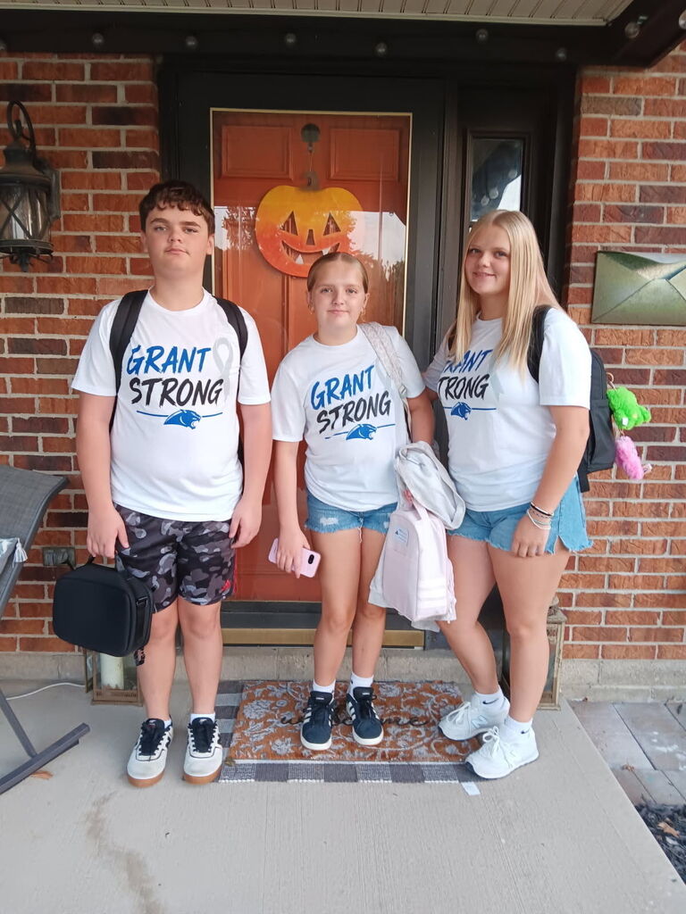 Two students pose with their Grant Strong t-shirts in support of their friend.