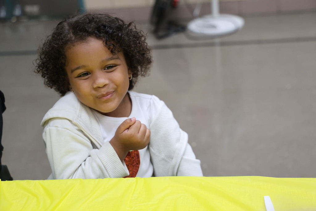 A cute kindergarten students reacts to the taste of pumpkin bread.