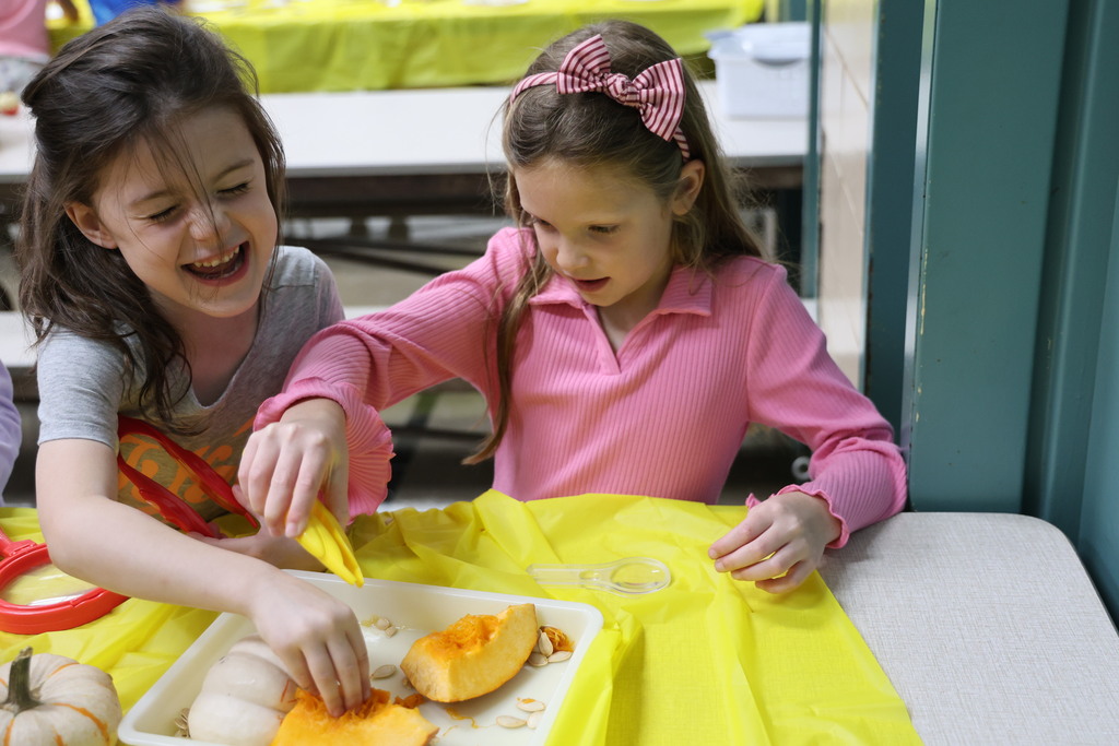 Two Broadway students explore the slimy insides of the pumpkin.