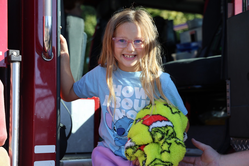 A student smiles after seeing the inside of a fire truck.