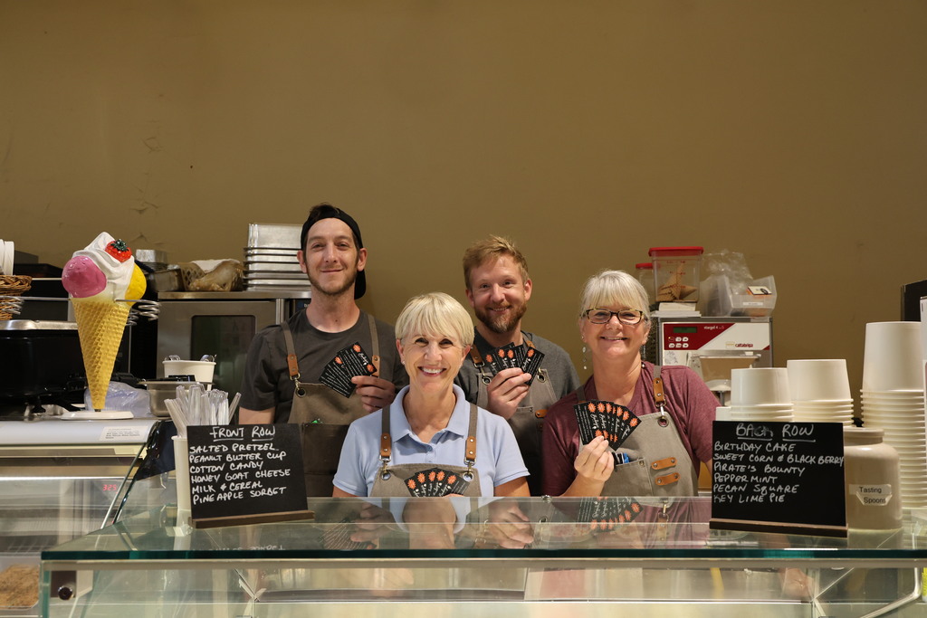 Bodega employees hold up the coupons for a free scoop of ice cream.