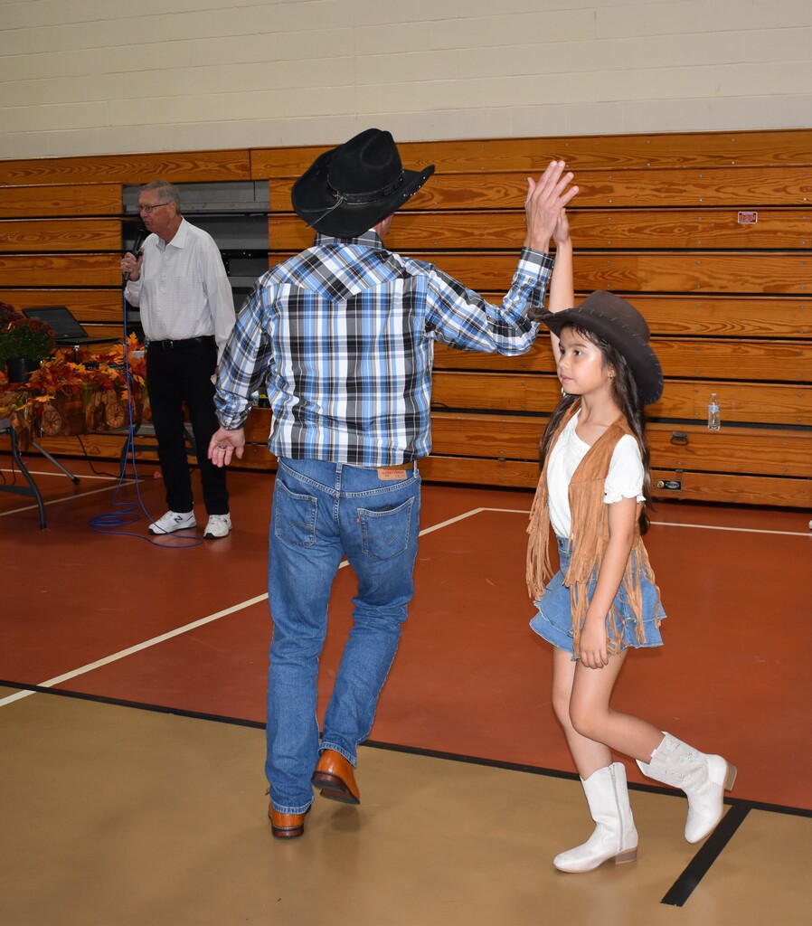 A father and his daughter dance at the Hoe Down.  