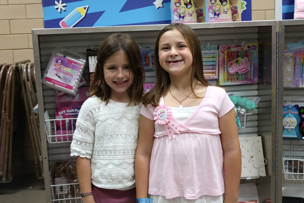 Two girls at Broadway's book fairs are excited to look at the merchandise.