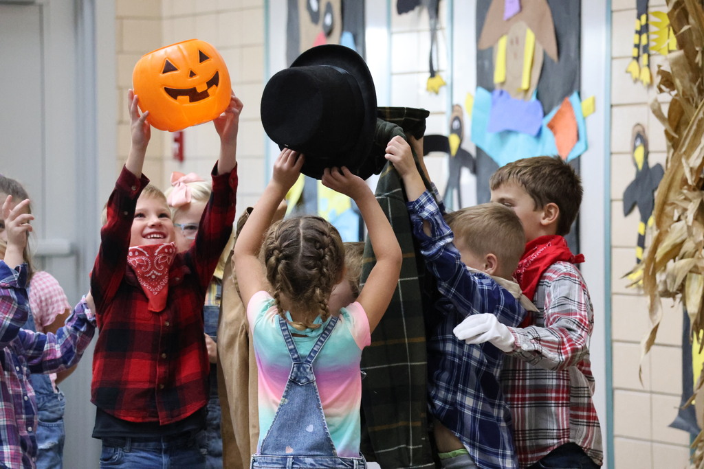 Students are building a scarecrow during their fall play.
