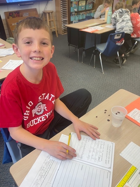Students smiling as they work on a science experiment.