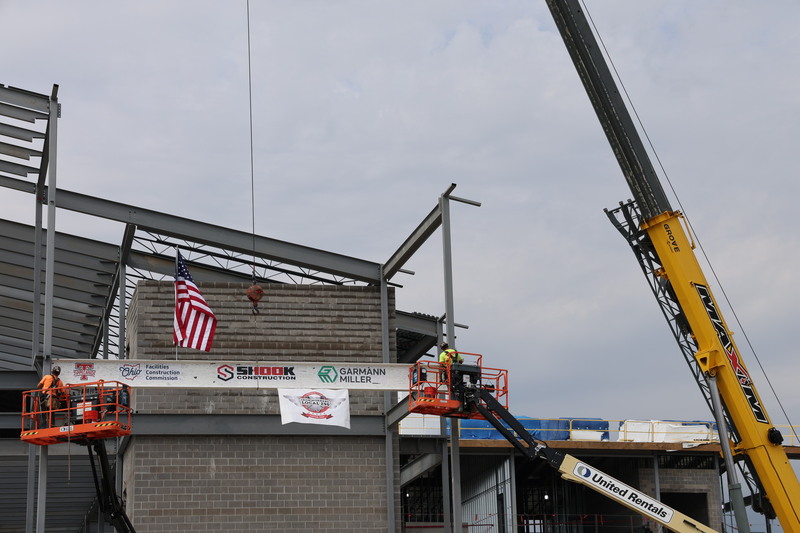A crane lifts the beam.