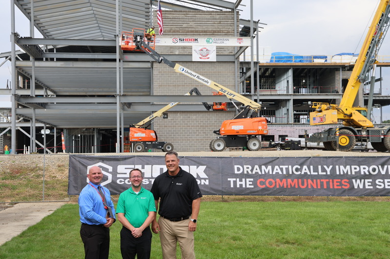 Garmann Miller teams members stand in front of the new school where the beam was installed.