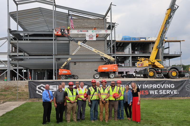 Employees of Shook Construction pose with the superintendent after the beam was installed.
