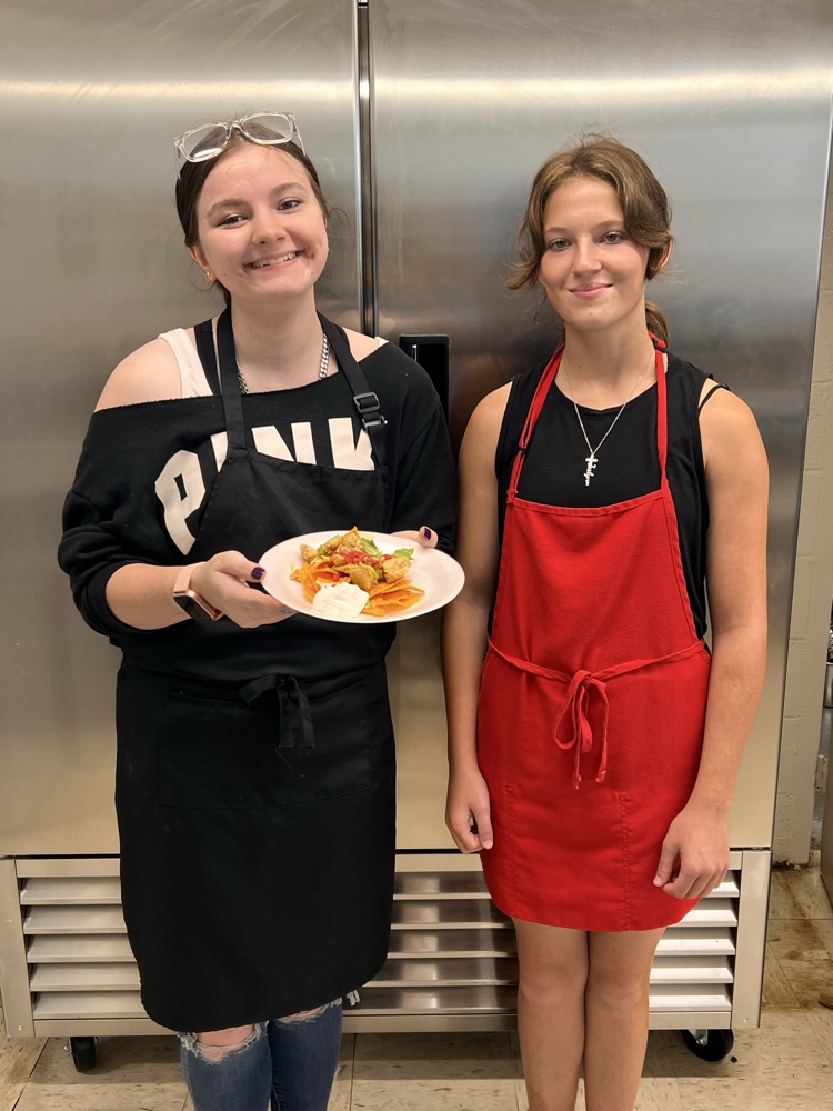 Students posing with finished dishes in Culinary class. 