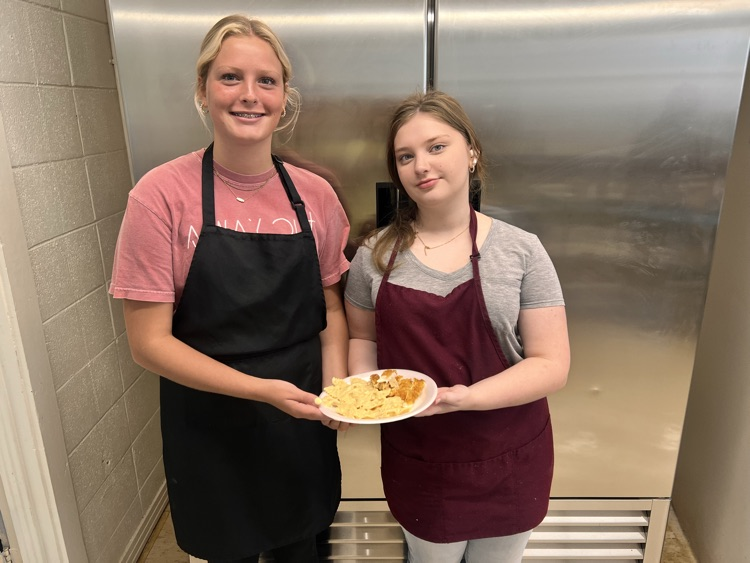 Students posing with finished dishes in Culinary class. 