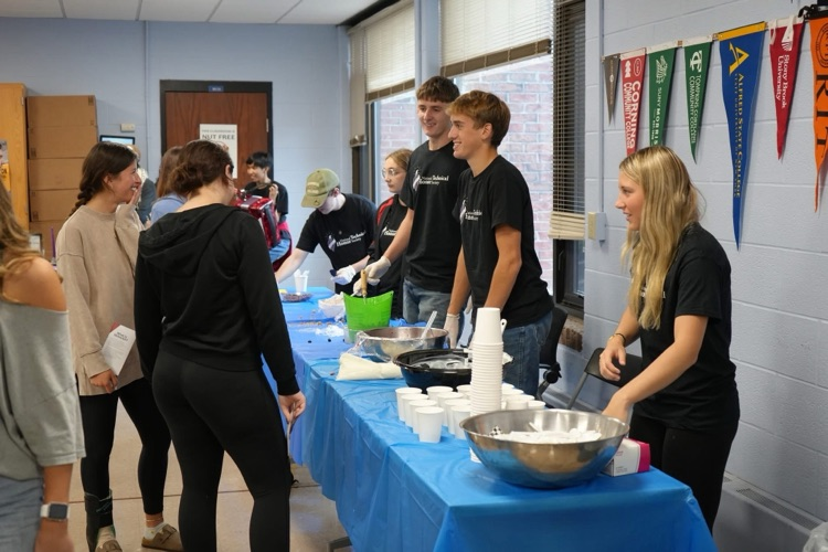 students serving parfaits to other students