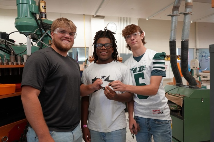three students with machined part