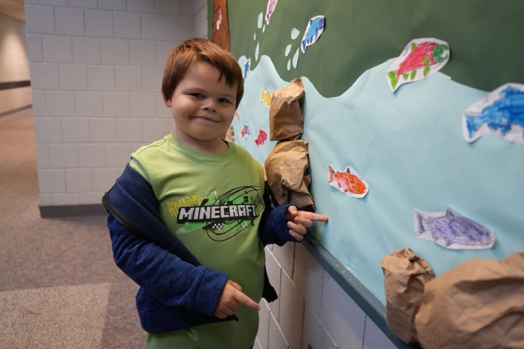 student showing off art work